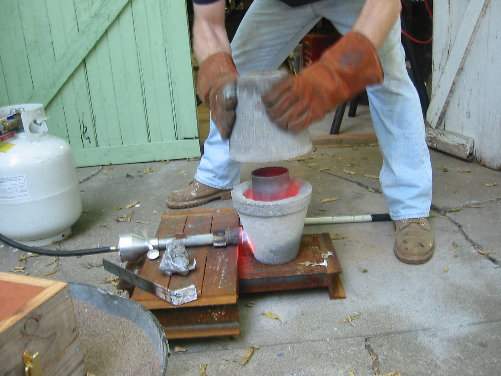 (14) Time to melt some aluminum. This is my flower pot furnace, the details are above. Wait until the melt begins to glow orange. Thermometers are not necessary. Too cold and the pour will choke. Too hot and there will be small bubbles. After a couple of mistakes you will know when it's perfect.