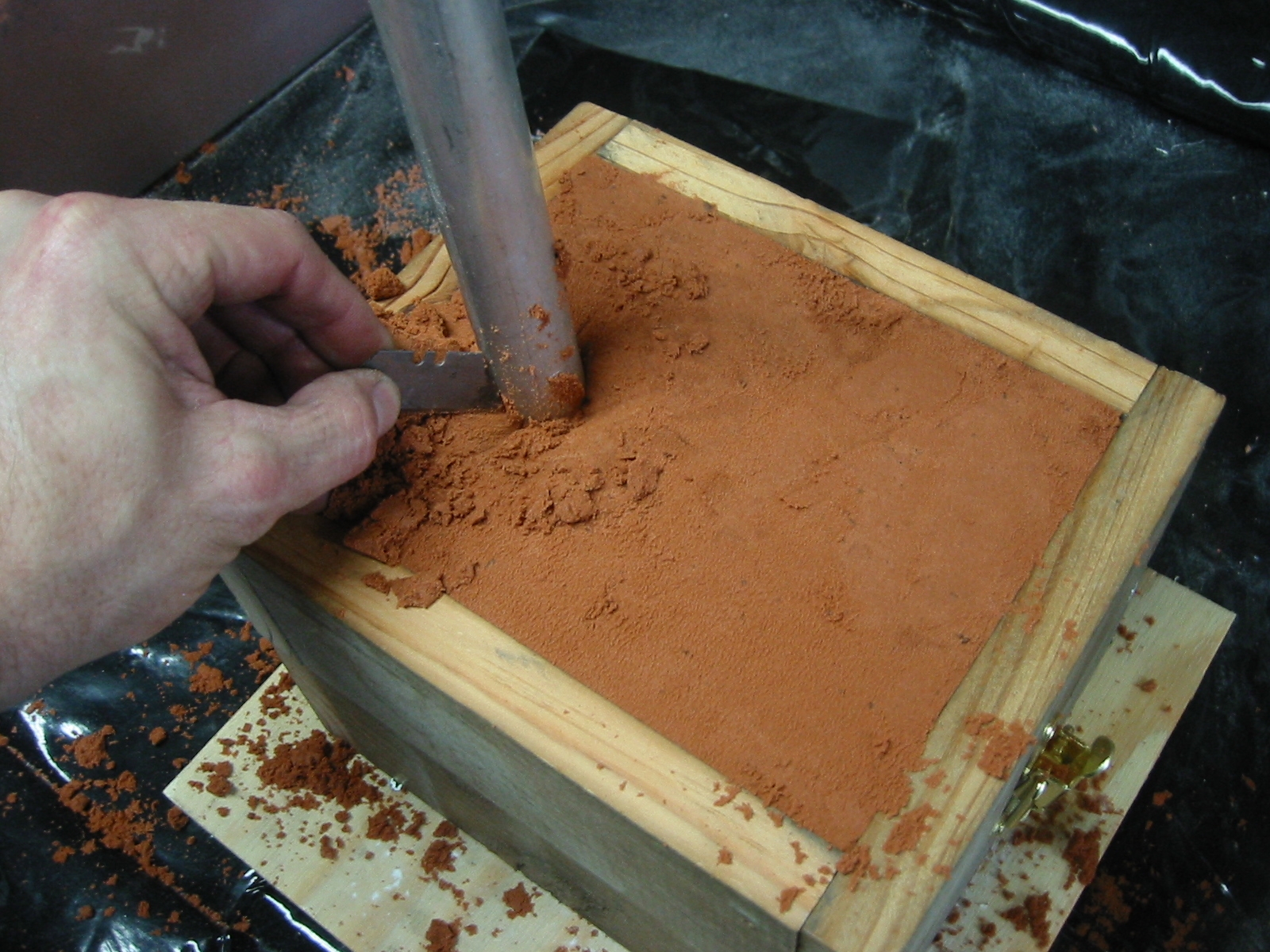 (9) Flatten off the sand level the the top edge of the frame or